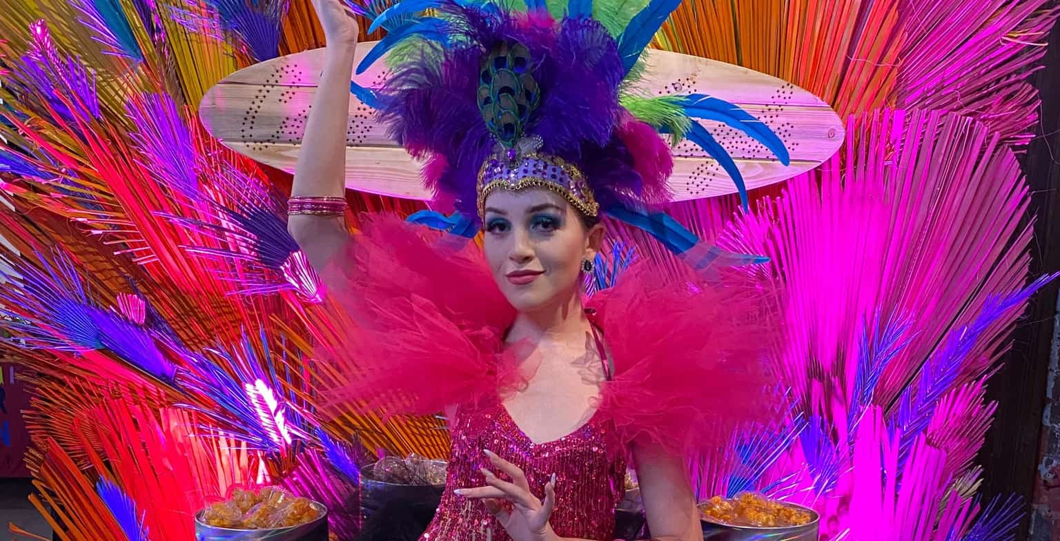A Carnivale showgirl in rainbow plumage presides over a Storybook confection table