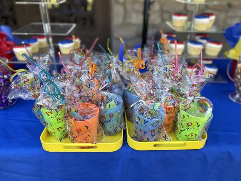 Wrapped favor cups with silly straws, trayed for every guest