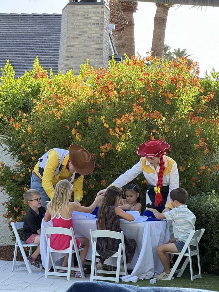 Two costumed performers work the kids tables at a garden celebration