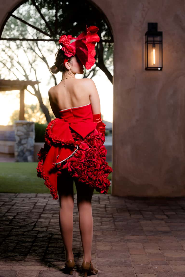 A model in an elaborate red rose-couture gown and headpiece at an upscale event